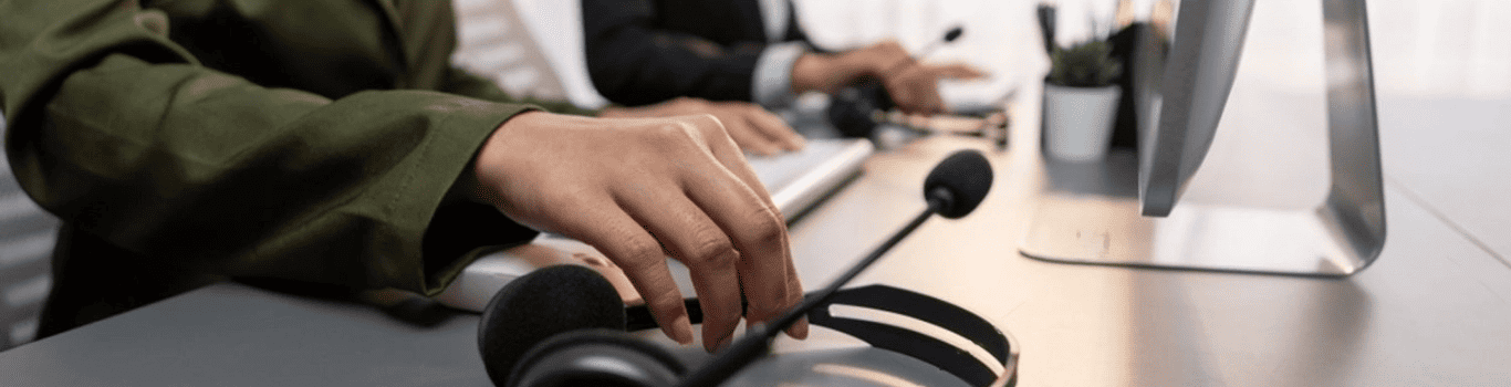 Mujer trabaja en su escritorio con computadora y audífonos